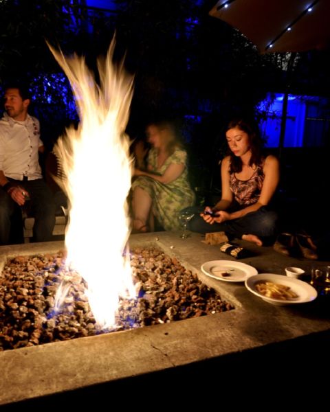 people sitting around a fire pit at night