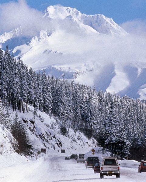 cars driving on snowy highway towards a snow covered Mount Hood