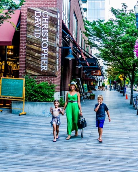 a woman and two children walking down the sidewalk in the Pearl