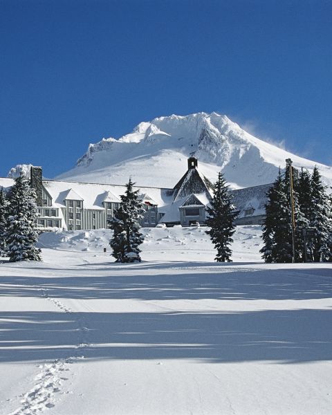 Timberline lodge covered in snow on a sunny day