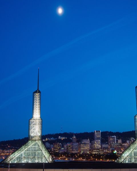 the exterior of the Oregon Convention Center lit up at night