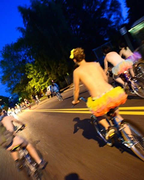 people on bikes at night wearing very little clothing