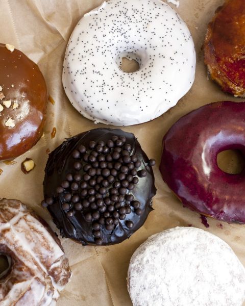 seven gourmet donuts on parchment paper