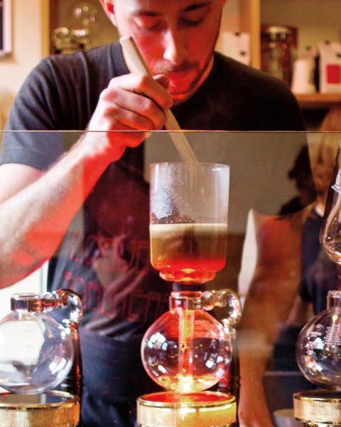 a barista creates a pour-over coffee drink