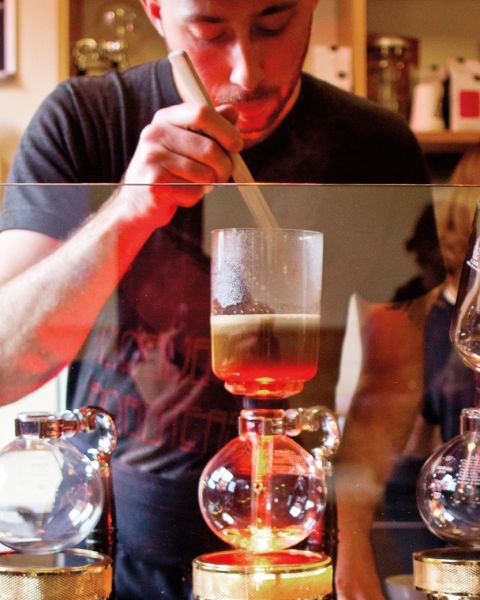 A barista creates a pour-over coffee drink