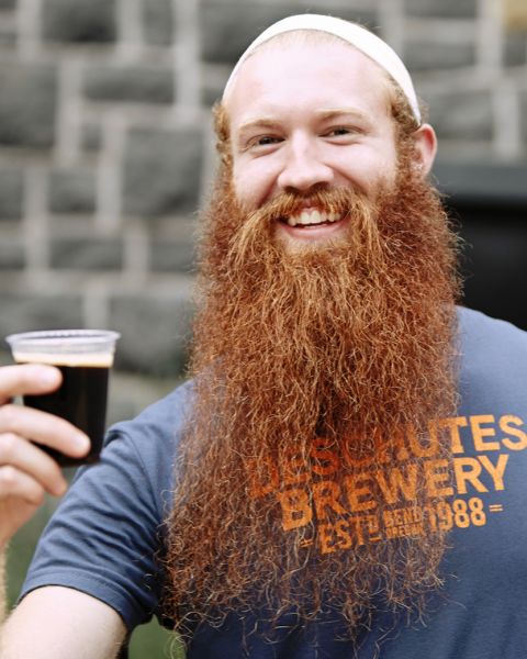 A very happy man with a long red beard enjoying a dark beer at the Deschutes Brewery Street Fare.