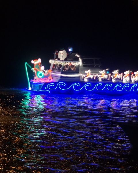 Two boats adorned with Christmas lights