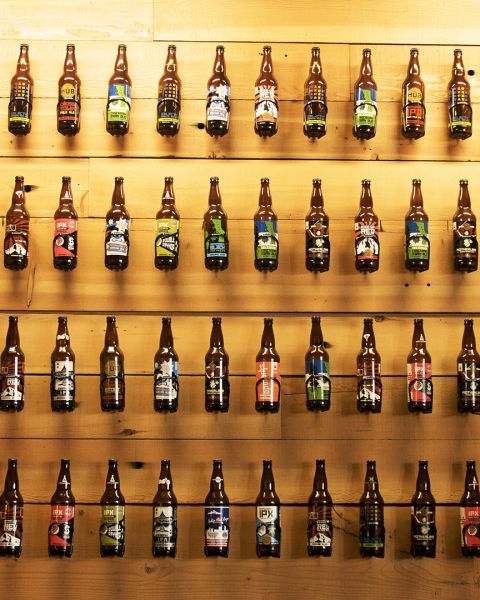 beer bottles displayed in lines against a wall