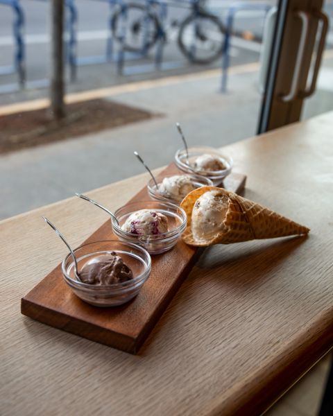 an ice cream sampler consisting of four small bowls and one sugar cone