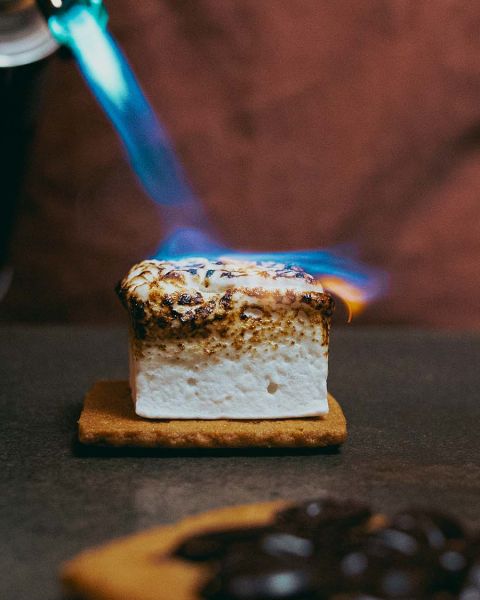 Someone torches a marshmallow smore.