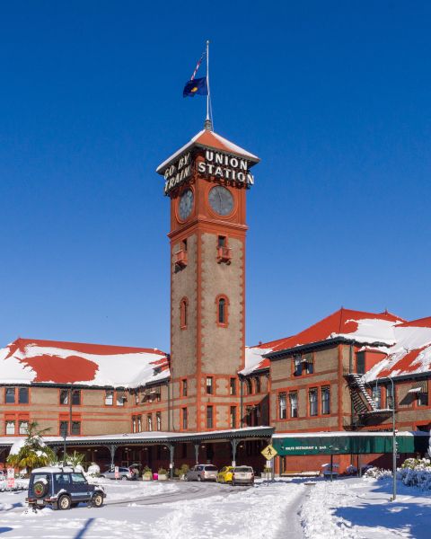 train station surrounded by snow-covered streets and shrubs