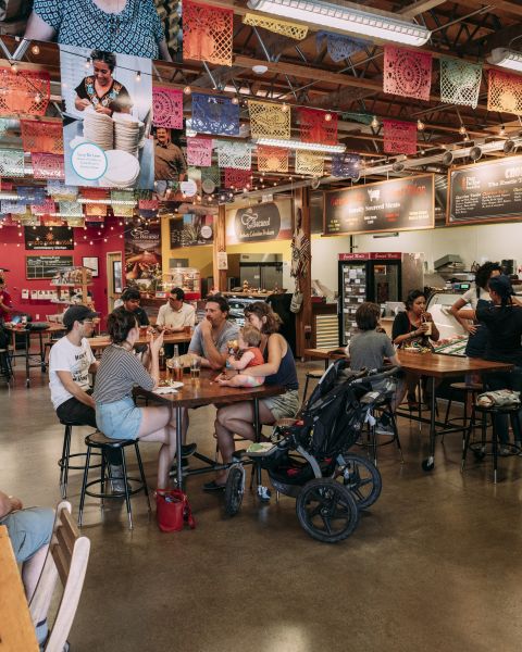 groups of people at tables in an indoor market dining area