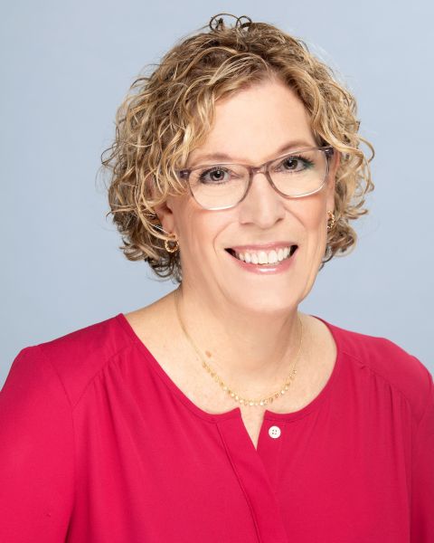 Woman with bright red blouse headshot