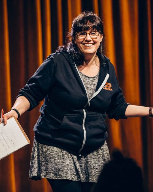 a woman holding a clipboard on stage
