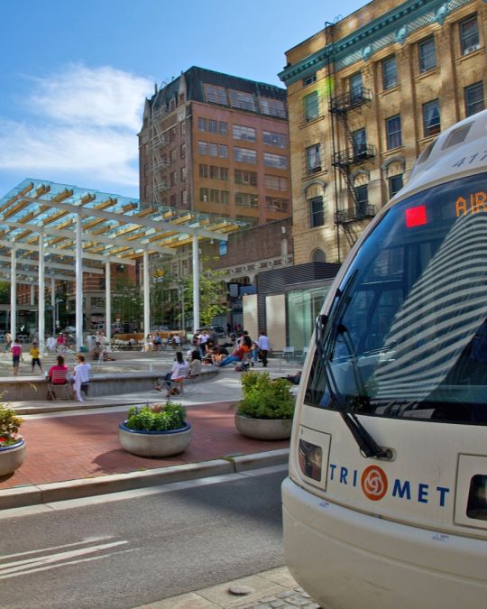 a MAX lightrail car passes by Director Park on it\'s way to the airport