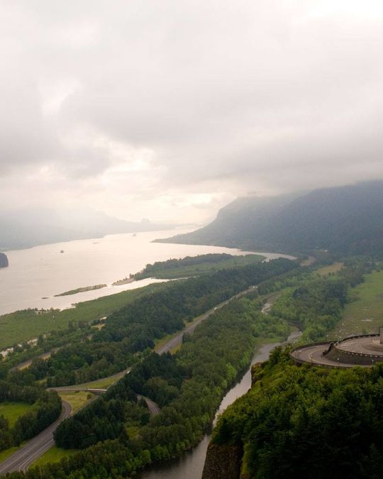 A magnificent view up the Columbia River Gorge, the golden light of a setting sun hitting the cliffs below the Vista house.