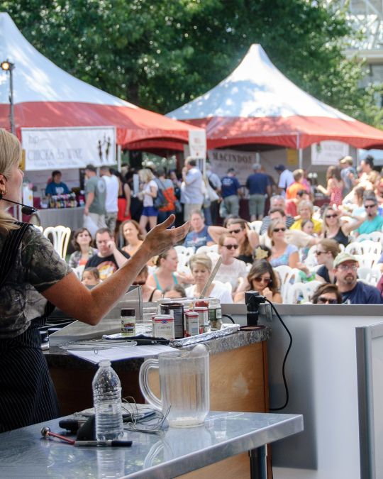 a woman presents information to an outdoor crowd