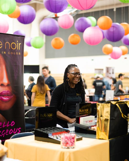 A vendor greets an attendee at My People\'s Market