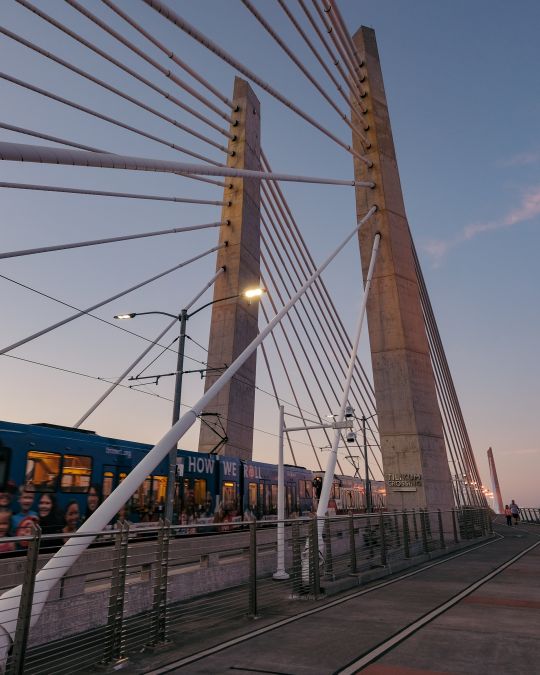 A light rail train crosses a bridge