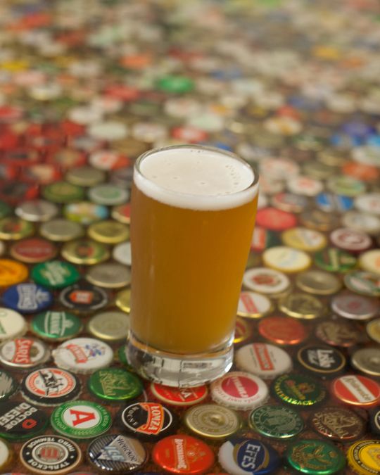 Pint of beer on bottlecap table