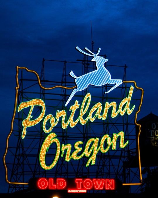 A sign made of light bulbs form the silhouette of the state with a stag jumping over the words Portland Oregon