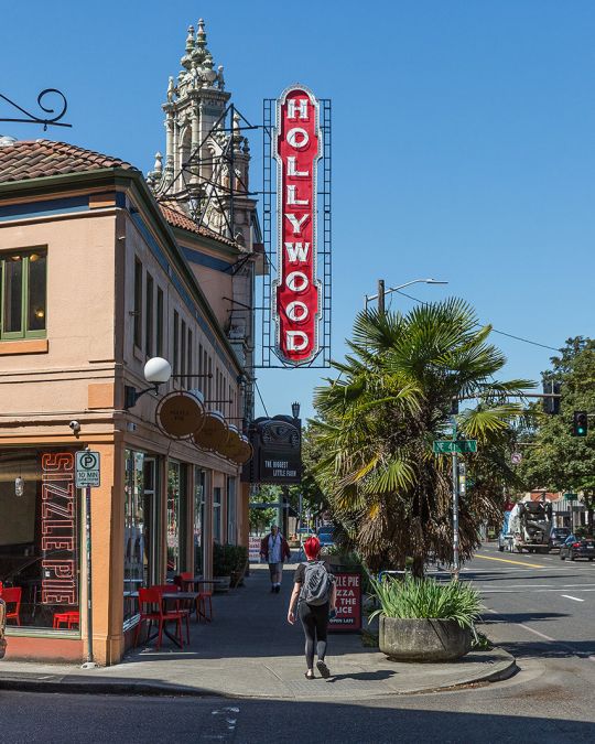 people walking on the sidewalk under a vintage Hollywood Theater sign