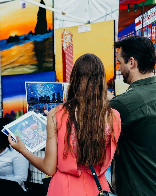 two people look at art on display