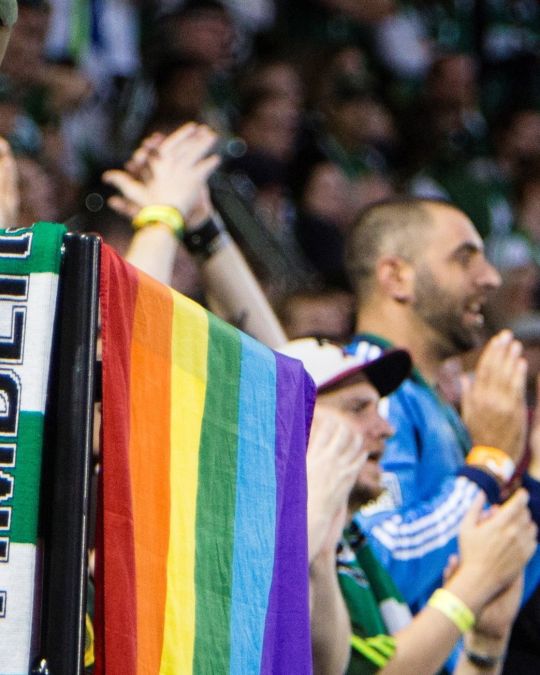 a group of Portland Timbers football fans celebrate at a game