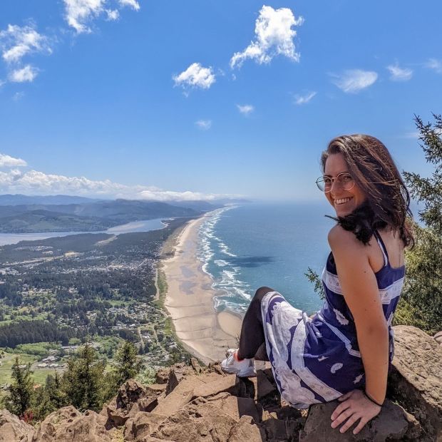 an image of a person sitting on top of a mountain over looking the Oregon Coast