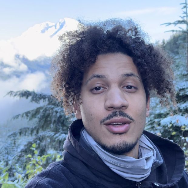 close up of a person's face with a snowy mountain in the background