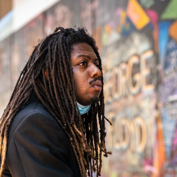 image of a person facing away from the camera with a mural behind them