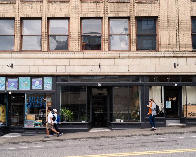street view of people walking icy store fronts with colorful window displays