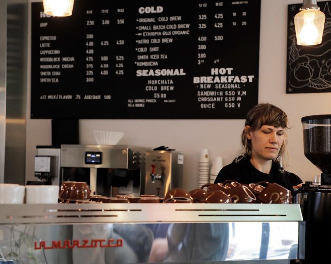 person preparing a cup of coffee at a coffee shop