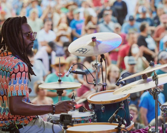 a person sitting at a drum kit in front of a crowd