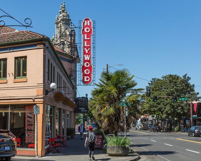people walking on the sidewalk under a vintage Hollywood Theater sign