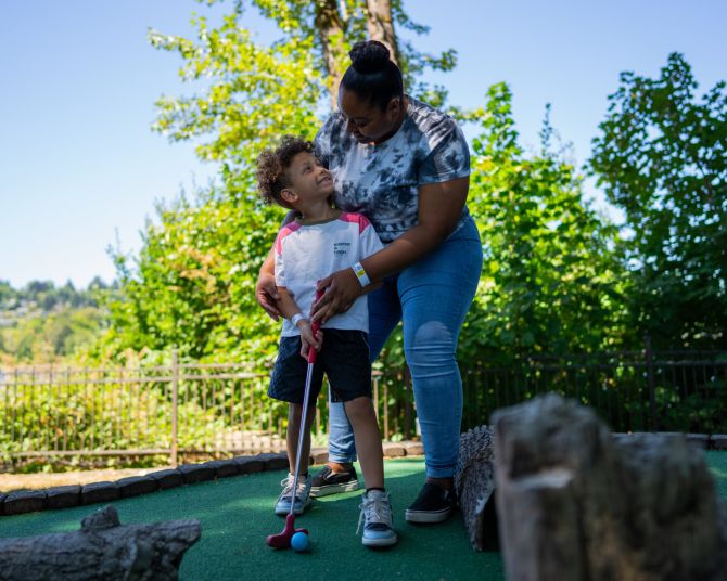 a mother and son playing mini golf