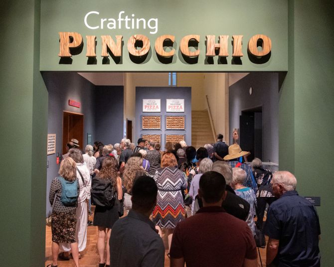 a crowded gallery exhibition labeled Crafting Pinnochio