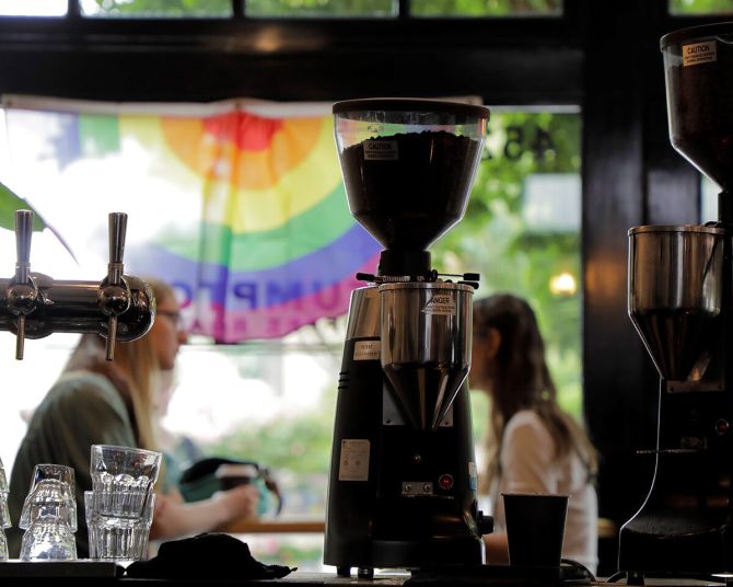two people sit at a window in a coffee shop