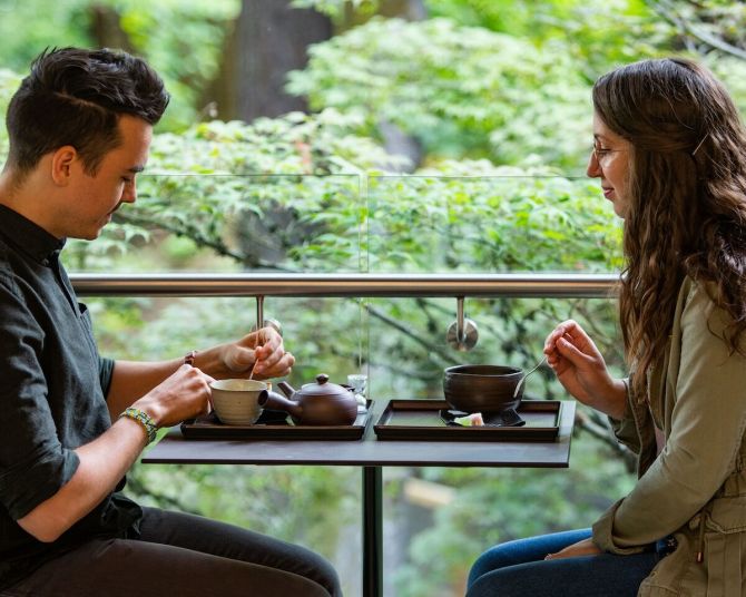 A couple sits enjoying tea service.