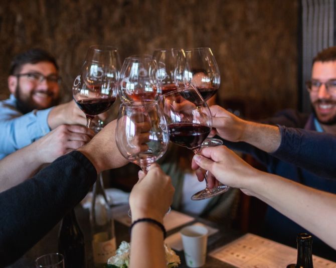 A small group toasts with glasses of wine