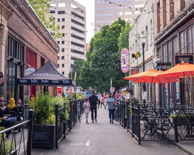 string lights and tables in the alley between restaurants and bars in Old Town Portland