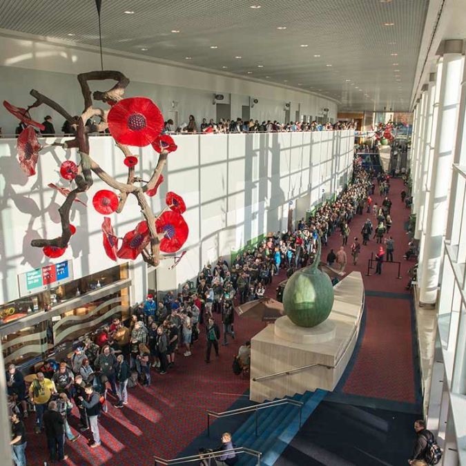 a crowd of people walking in the hallway of the Convention Center