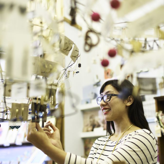 A person looking through a jewelry display at Tender Loving Empire.