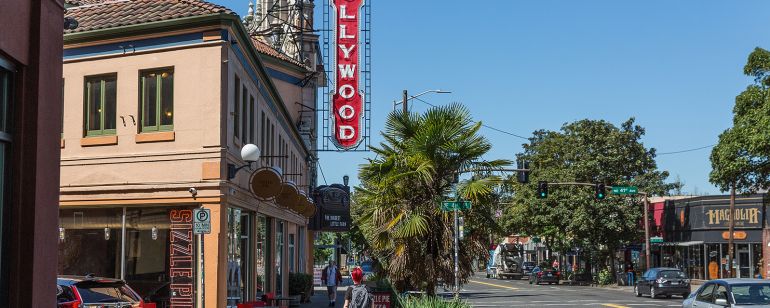 people walking on the sidewalk under a vintage Hollywood Theater sign