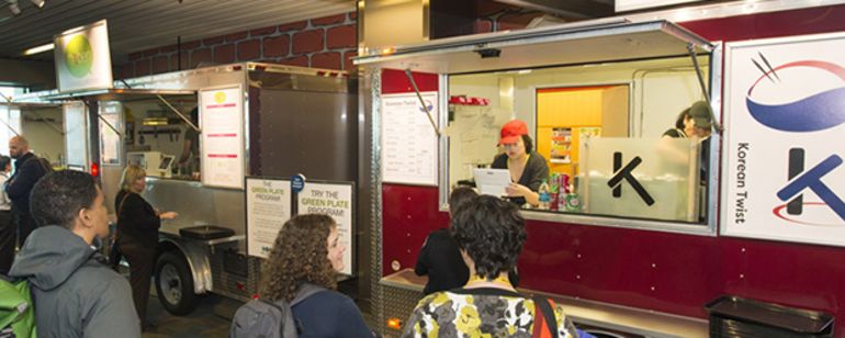 people in line at a food cart in the Portland Airport