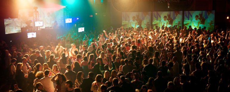 a crowd of people dancing in a night club