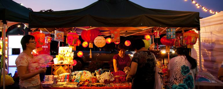 person selling products under a tent at an outdoor market