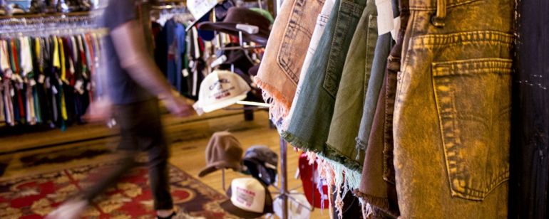 racks of clothing and hats on display at the Red Light Clothing Exchange