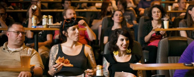 movie goers enjoy pizza and beer