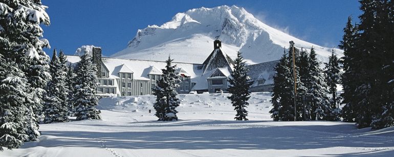 Timberline lodge covered in snow on a sunny day